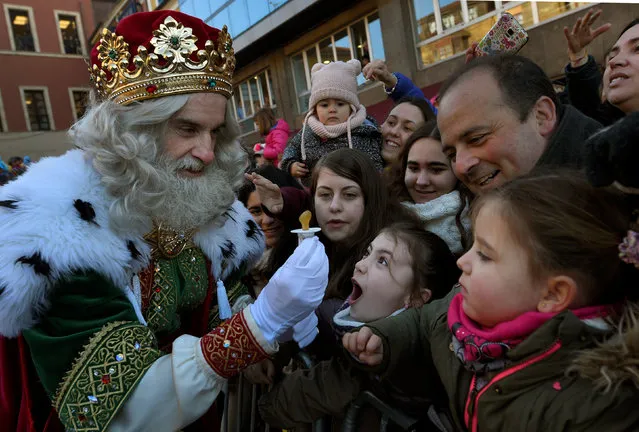 A man dressed as one of the Three Kings receives a baby pacifier from a girl during the Epiphany parade in Gijon, Spain January 5, 2017. (Photo by Eloy Alonso/Reuters)