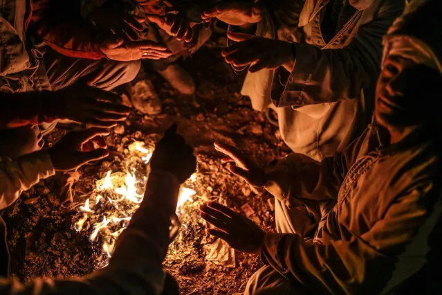 In this Wednesday, March 18, 2015 photo, quarry workers try to keep themselves warm around a bonfire as they wait for work after dawn in Shurafa village, Minya, southern Egypt. (Photo by Mosa'ab Elshamy/AP Photo)