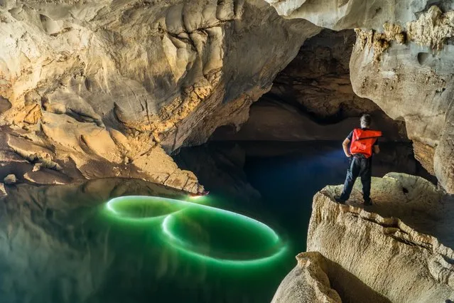 Water painting with kayaks and submerged LED lights near the downstream entrance of the cave on March 2015 at Tham Khoun Ex, Laos. (Photo by John Spies/Barcroft Media/ABACAPress)