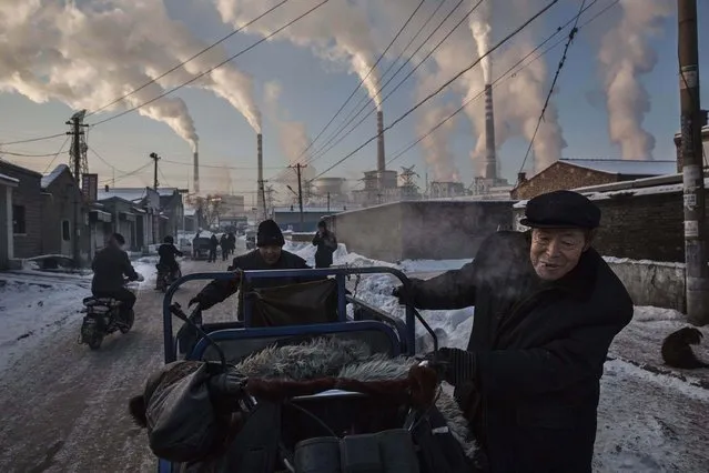 “China's Coal Addiction”. Daily Life, first prize singles. Kevin Frayer, Canada, Getty Images. Location: Shanxi, China. Chinese men pull a tricycle in a neighborhood next to a coal-fired power plant in Shanxi, China, November 26, 2015. A history of heavy dependence on burning coal for energy has made China the source of nearly a third of the world's total carbon dioxide (CO2) emissions, the toxic pollutants widely cited by scientists and environmentalists as the primary cause of global warming. (Photo by Kevin Frayer/World Press Photo Contest)