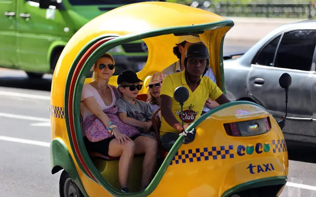 A picture made available on 03 January 2016 shows a tourist family in a 'coconut taxi' in Havana, Cuba, 02 January 2016. Tourism industry in Havana is expected to make a new record of visitors in 2016, coming especially from the United States when flights and ferry itineraries have been re-established. Cuba and USA have agreed to establish new commercial flights as part of an agreement that is expected to include 30 regular daily flights, paving way to thousands of US tourists to visit to country. (Photo by Alejandro Ernesto/EPA)