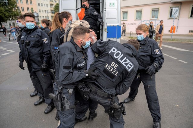 Police restrain a demonstrator, during a protest against coronavirus restrictions, in Berlin, Saturday, August 28, 2021. (Photo by Christophe Gateau/dpa via AP Photo)