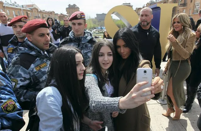 U.S. television personality Kim Kardashian (R, front) poses for a picture with local residents, with her sister Khloe Kardashian standing nearby, while sightseeing in central Yerevan, April 9, 2015. Kardashian received a rapturous welcome in her ancestors' homeland, Armenia, on a visit that could draw attention to the 100th anniversary of mass killings of Armenians in 1915. (Photo by Vahram Baghdasaryan/Reuters)
