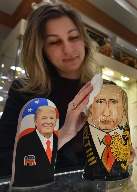 An employee polishes traditional Russian wooden nesting dolls, Matryoshka dolls, depicting US President-elect Donald Trump (L) and Russian President Vladimir Putin at a gift shop in central Moscow on January 16, 2017, four days ahead of Trump's inauguration. (Photo by Alexander Nemenov/AFP Photo)