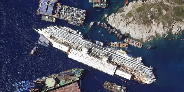 An aerial view shows the Costa Concordia as it lies on its side next to Giglio Island taken from an Italian navy helicopter August 26, 2013. (Photo by Alessandro Bianchi/Reuters)