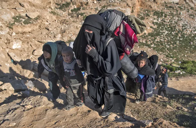 Civilians flee from the Baghouz area in the eastern Syrian province of Deir Ezzor on February 12, 2019 during an operation by the US-backed Syrian Democratic Forces (SDF) to expel hundreds of Islamic State group (IS) jihadists from the region. The ferocious battle for the Islamic State group's last bastion in eastern Syria entered its fifth day, as exhausted families left the ever-shrinking scrap of land where holdout jihadists have been boxed in by Kurdish-led forces. (Photo by Fadel Senna/AFP Photo)