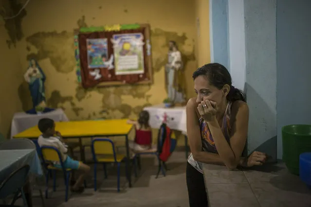 A volunteer waits for children to arrive for lunch in San Antonio de Padua popular dinning room in Petare slum, Caracas, Venezuela, Monday, February 11, 2019. (Photo by Rodrigo Abd/AP Photo)