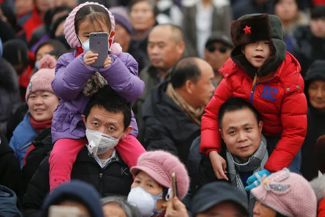 People, some wearing face mask against pollution, follow performers during a re-enactment of an ancient Qing Dynasty ceremony as the Lunar New Year of the Rooster is celebrated at the temple fair at Ditan Park (the Temple of Earth), in Beijing, China January 28, 2017. (Photo by Damir Sagolj/Reuters)