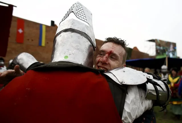 An injured fighter smiles as he hugs a fellow fighter during the Medieval Combat World Championship at Malbork Castle, northern Poland, April 30, 2015. (Photo by Kacper Pempel/Reuters)