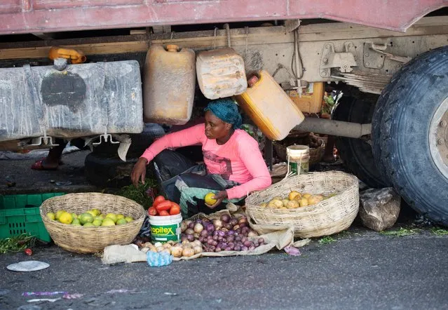A merchant sells her goods under a truck at a market in Petion-Ville, Port-au-Prince, after a missionary group including 16 Americans and one Canadian were kidnapped in Haiti on Saturday, in in Port-au-Prince, Haiti on October 17, 2021. (Photo by Ralph Tedy Erol/Reuters)
