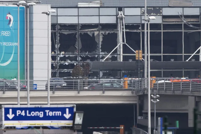 The blown out windows of Zaventem airport are seen after a deadly attack in Brussels, Belgium, Tuesday, March 22, 2016. Authorities in Europe have tightened security at airports, on subways, at the borders and on city streets after deadly attacks Tuesday on the Brussels airport and its subway system. (Photo by Peter Dejong/AP Photo)