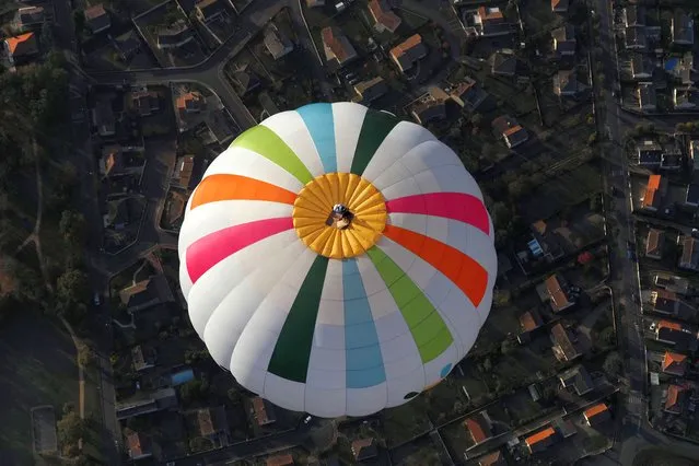 French balloonist Remi Ouvrard attempts to set a world record by standing on the top of a hot air balloon for the Telethon at an altitude of over 3637 meters on November 10, 2021 in Chatellerault, western France. The altitude should be the same of the phone number of the Telethon campaign 36-37. (Photo by Guillaume Souvant/AFP Photo)