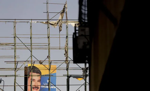 A billboard featuring Venezuela's President Nicolas Maduro is seen through an empty one in Caracas, Venezuela, Tuesday, March 19, 2019. Billboards often have nothing to promote, their skeletal framework bare long after the wind has ripped away old advertising. (Photo by Natacha Pisarenko/AP Photo)