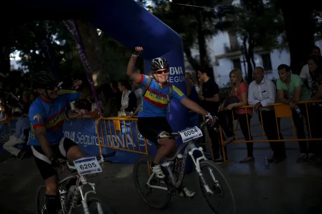 Spanish mountain bikers Elena Luisa Castillo (R) and Patricio Mudarra celebrate as they cross the finish line in the XVIII 101km international competition in Ronda, southern Spain, May 9, 2015. (Photo by Jon Nazca/Reuters)