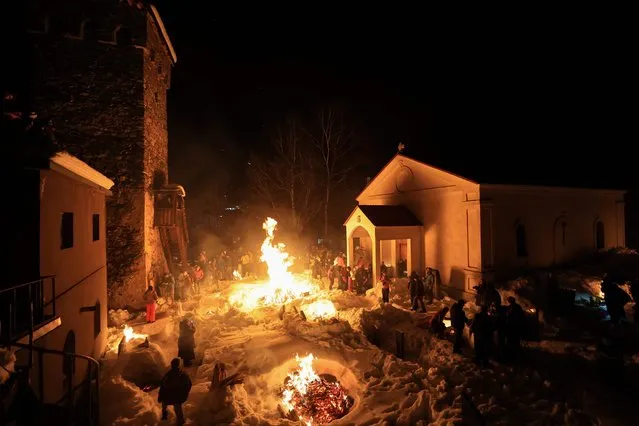 Georgians celebrate Lamproba, a traditional religious festival honouring the dead by burning fires at their graves, what is believed warming their souls, in the highland townlet of Mestia, located at an elevation of 1,500 metres (4,921 feet) in the Caucasus Mountains, in northwestern Georgia's Svaneti region on February 14, 2024. (Photo by Giorgi Arjevanidze/AFP Photo)