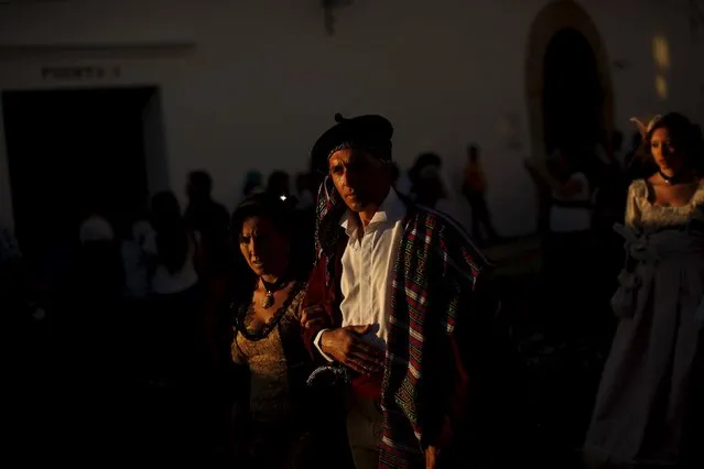 A couple dressed as bandits and a woman (R) dressed as a bourgeois walk at sunset as they participate in the third edition of “Ronda Romantica” (Romantic Ronda) in Ronda, southern Spain, May 16, 2015. (Photo by Jon Nazca/Reuters)