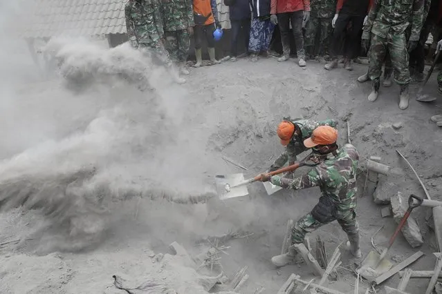 Soldiers search for the victims in a location where a house is buried beneath volcanic ash from the eruption of Mount Semeru in Candi Pure village, Lumajang, East Java, Indonesia, Tuesday, December 7, 2021. (Photo by Trisnadi/AP Photo)