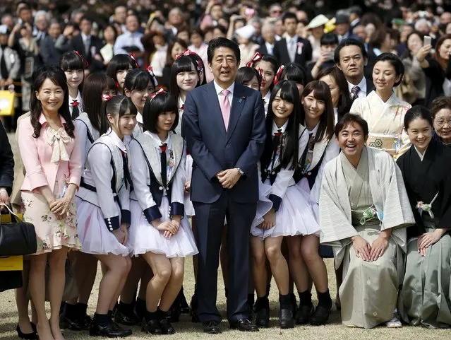 Japan's Prime Minister Shinzo Abe (C) poses with members of Japanese idol group NGT48 and other show-business celebrities at a cherry blossom viewing party at Shinjuku Gyoen park in Tokyo, Japan April 9, 2016. (Photo by Toru Hanai/Reuters)