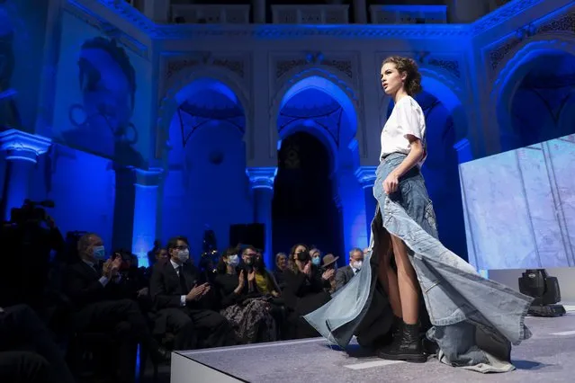 A model takes to the catwalk inside the 19th century building City Hall in Sarajevo, Bosnia, Thursday, December 16, 2021, during the presentation of a collection dubbed “No Nation Fashion”, a migrant-made fashion brand project. At the fashion show migrant models came out on the catwalks in designs meant to symbolize various stages of their journeys – the “nomadic” road away from home and the transit to new lives in new countries while the panel in the background read “We are strong”, and “We smile”. (Photo by AP Photo/Stringer)