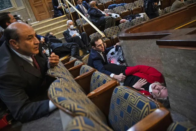 Rep. Jason Crow, D-Colo., comforts Rep. Susan Wild, D-Pa., while taking cover as protesters disrupt the joint session of Congress to certify the Electoral College vote on Wednesday, January 6, 2021. (Photo By Tom Williams/CQ-Roll Call, Inc via Getty Images)