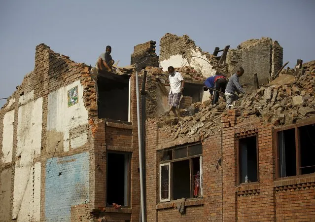 People work to clear debris from collapsed houses, a month after the April 25 earthquake in Kathmandu, Nepal May 25, 2015. (Photo by Navesh Chitrakar/Reuters)