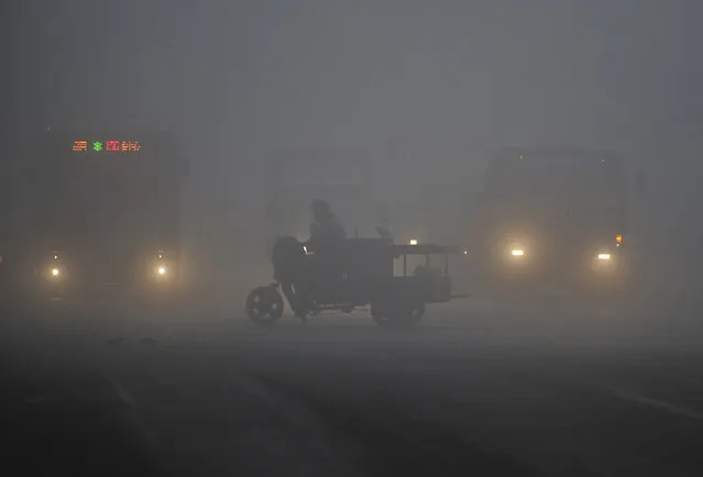 A tricycle travels past a crossroad on a hazy day in Hefei, Anhui province March 30, 2014. China's plan for a market in air pollution permits promises to help clean up its air cheaply, but the move could prove just as useless as previous environmental policies unless the government stamps out lax enforcement and spotty data. (Photo by Reuters/Stringer)