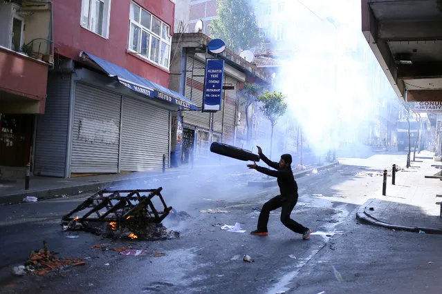 Leftist demonstrators set on fire a barricade as they clash with riot police using tear gas to disperse them during May Day celebrations in Istanbul, Sunday, May 1, 2016. (Photo by Cagdas Erdogan/AP Photo)