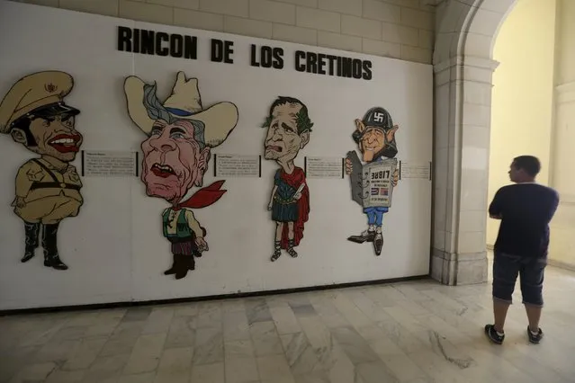 A man looks a display entitled, “Corner of the Cretins” in reference to (L to R) Cuban dictator Fulgencio Batista, former U.S. Presidents Ronald Reagan, George Bush Sr. and George W. Bush, at the Museum of the Revolution in Havana July 1, 2015. (Photo by Enrique de la Osa/Reuters)