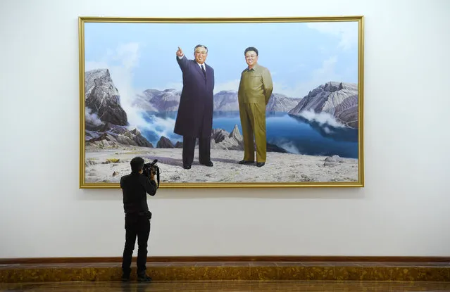 Foreign media films a large portrait of Kim Il Sung and his son Kim Jong Il hung in the lobby of an upscale hotel in Pyongyang, North Korea on May 4, 2016. (Photo by Linda Davidson/The Washington Post)