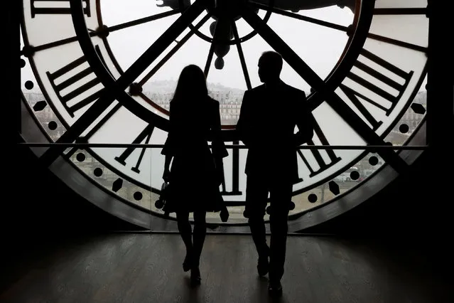 Britain's Prince William, Duke of Cambridge, and his wife Britain's Catherine the Duchess of Cambridge look across the River Seine through the clock face at the Musee d’Orsay, the former Gare d'Orsay train station, during their visit to the museum in Paris, France March 18, 2017. (Photo by Francois Guillot/Reuters)