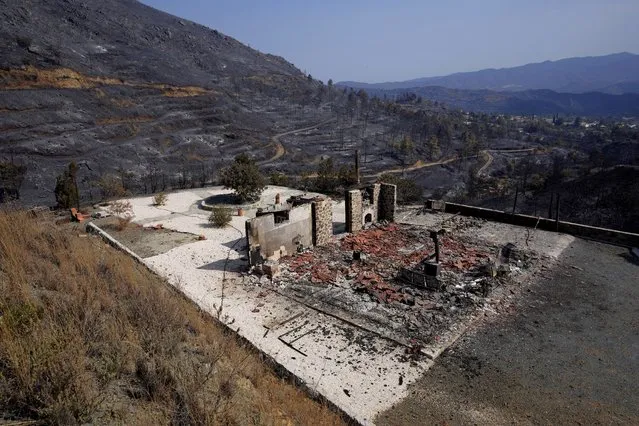 A burnt house is seen on outskirts of Ora village, in the background is the Larnaca mountain region, Cyprus, Sunday, July 4, 2021. Cyprus' interior minister says four people have died in what he called the “most destructive” fire in the island nation's history. (Photo by Petros Karadjias/AP Photo)