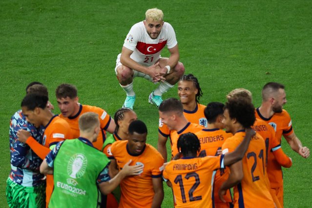 Turkey's forward #21 Baris Alper Yilmaz reacts as Netherlands' players celebrate after the UEFA Euro 2024 quarter-final football match between the Netherlands and Turkey at the Olympiastadion Berlin in Berlin on July 6, 2024. (Photo by Ronny Hartmann/AFP Photo)