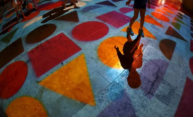 A child plays within Pixels Wave 2015, a giant carpet of moving lights on the ground in an interactive virtual reality installation by Mexican-born experimental and multidisciplinary artist Miguel Chevalier, during the Malta International Arts Festival at the entrance to Valletta, Malta, July 17, 2015. (Photo by Darrin Zammit Lupi/Reuters)