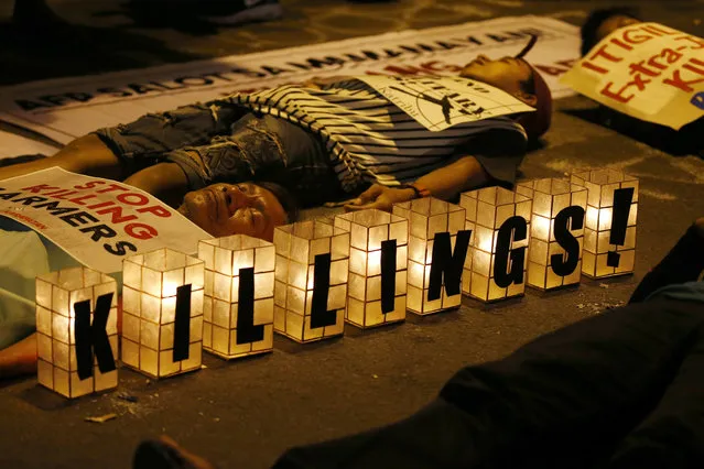 Protesters stage a die-in during a rally near the Presidential Palace to protest the “extrajudicial killings” under President Rodrigo Duterte's so-called war on drugs which coincided with the U.N. Human Rights Council Universal Periodic Review in Geneva, Switzerland, Monday, May 8, 2017 in Manila, Philippines. Filipino Senator Alan Peter Cayetano briskly defended the human rights record of Duterte's government before the U.N. body in Geneva on Monday, saying his government always “seeks to uphold the rule of law” while critical Western nations aired concerns about deadly vigilante justice and extrajudicial killings in the country. (Photo by Bullit Marquez/AP Photo)