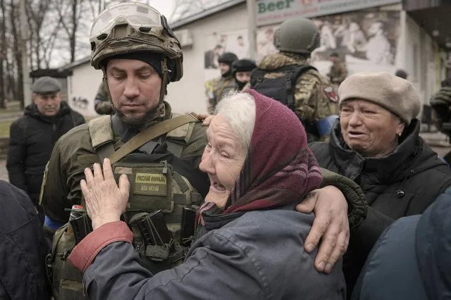 A woman hugs a Ukrainian serviceman after a convoy of military and aid vehicles arrived in the formerly Russian-occupied Kyiv suburb of Bucha, Ukraine, Saturday, April 2, 2022. (Photo by Vadim Ghirda/AP Photo)