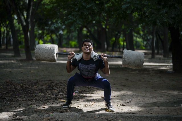 Daniel Fonseca, 15, lifts blocks of cement at a public gym set up at Los Caobos Park in Caracas, Venezuela, Tuesday, July 23, 2024. Venezuela is set to hold its presidential election on July 28. (Photo by Fernando Vergara/AP Photo)