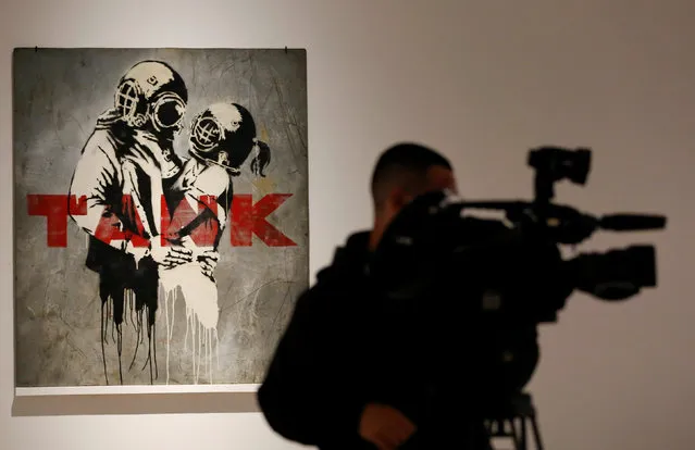 A cameraman films artworks by British street artist known as Banksy during the exhibition “War, Capitalism & LIiberty” organized by “Fondazione Terzo Pilastro” in Rome, Italy May 23, 2016. (Photo by Tony Gentile/Reuters)
