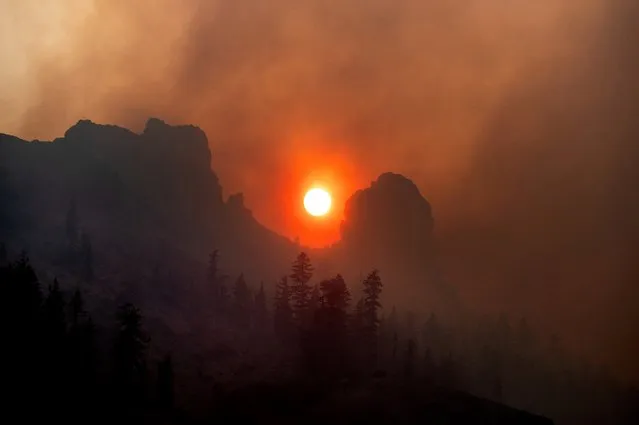 Smoke from the Caldor Fire wafts over a ridgetop near Kirkwood Ski Resort in Eldorado National Forest, Calif., on Tuesday, August 31, 2021. (Photo by Noah Berger/AP Photo)
