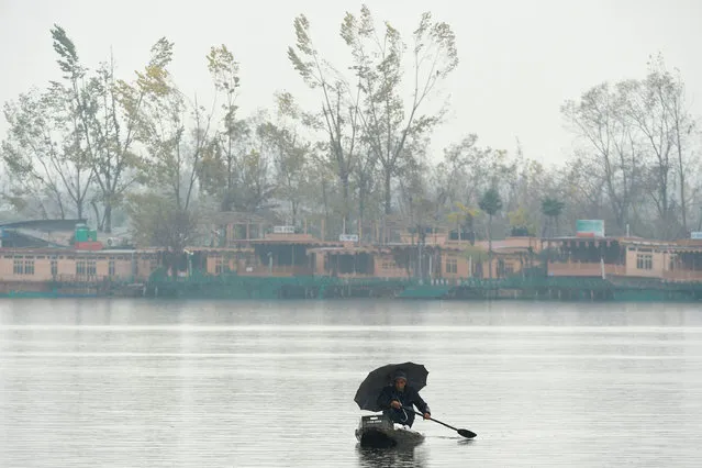 A Kashmiri man rows a boat in the waters of Dal Lake as it rains in Srinagar on November 22, 2019. (Photo by Tauseef Mustafa/AFP Photo)