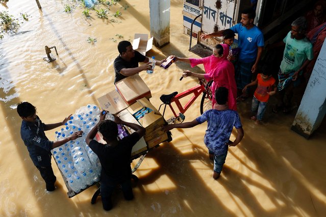 Flood-affected people receive relief supplies as they take shelter in a madrasa in the Chhagalnaiya area, in Feni, Bangladesh on August 24, 2024. (Photo by Mohammad Ponir Hossain/Reuters)