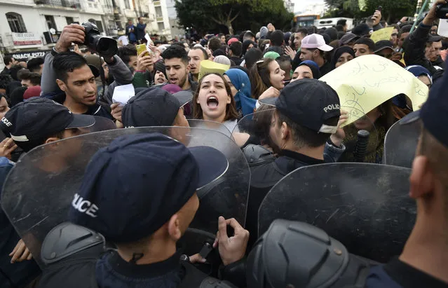 Algerian security forces contain protesters shouting slogans during an anti-government demonstration in the capital Algiers on December 9, 2019, ahead of the presidential vote scheduled for December 12. Algeria's contentious presidential election campaign is highlighting the vast gap between youth at the heart of a reformist protest movement and an ageing elite they see as clinging to power. The poll will see five candidates, all linked to ex-president Abdelaziz Bouteflika, compete for the top office. But protesters, whose mass mobilisation forced the ex-strongman to resign from his two-decade tenure in April, have rallied weekly to say sweeping reforms must come ahead of any vote. (Photo by Ryad Kramdi/AFP Photo)