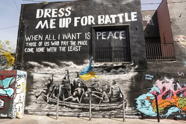 A mural titled “Dress Me Up for Battle” by street artist Bandit is painted on a building wall on Melrose Ave., in Los Angeles, Monday, March 21, 2022. (Photo by Eugene Garcia/AP Photo)