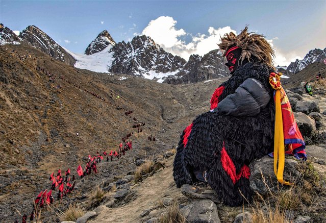 Devotees climb up the skirts of the Sinakara Mount to reach the shrine of the Lord of Qoylloriti (Star of the Lord of the Snow) on June 6, 2023, at 4,700 meters above sea level and at freezing temperatures in the Vilcanota mountain range in the province of Quispicanchis, district of Ocongate, at a locality 1,000 kilometers southeast of Lima. The festival begins on the day of the Holy Trinity, when thousands of pilgrims ascend to the limit of the perpetual snow cap in a ritual associated with the fertility of the land and the worship of the Apus (hills, tutelary gods). (Photo by Christian Sierra/AFP Photo)