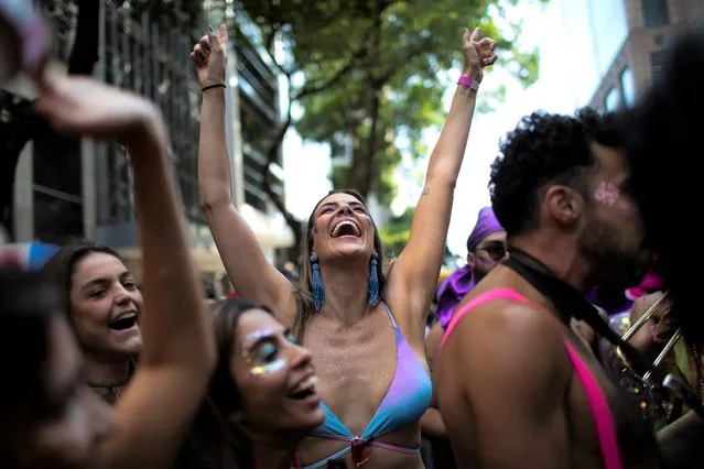 Revelers dance during an unofficial street party called “blocos” in Rio de Janeiro, Brazil, Thursday, April 21, 2022. The municipality of Rio de Janeiro postponed the annual samba school Carnival parades to April 22 - 23, but City Hall refused to grant authorization to the more than 500 blocos that accompany Carnival celebrations, claiming it lacked sufficient time to prepare. (Photo by Bruna Prado/AP Photo)