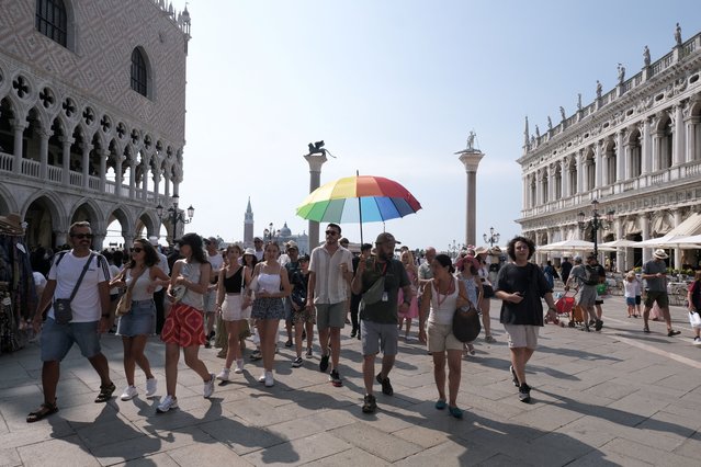 Tourist walk in Saint Marks Square on the day Venice municipality introduces a limit for tourist groups to 25 people to protect the fragile lagoon city and reduce the pressure of mass tourism in Venice, Italy, on August 1, 2024. (Photo by Manuel Silvestri/Reuters)