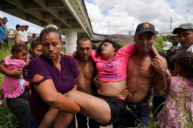 Brenda, a Honduran girl who is seeking asylum in the U.S., is carried from the Rio Grande in distress, where she had been bathing across the river from a Brownsville, Texas U.S. Customs and Border Protection tent facility as immigration hearings were being held by video teleconference, in Matamoros, Mexico September 12, 2019. Most of the people living in an encampment near the Gateway International Bridge have been sent back under the “Remain in Mexico” program, officially named Migrant Protection Protocols (MPP). (Photo by Veronica G. Cardenas/Reuters)