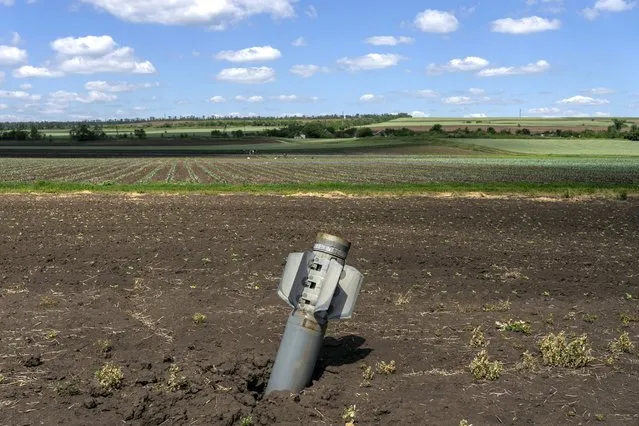 An unexploded Russian rocket lays on a field near Soledar, eastern Ukraine, Monday, June 6, 2022. (Photo by Bernat Armangue/AP Photo)