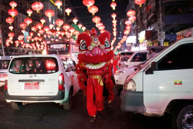 Members from a lion dance crew make their way through traffic as the greet people on the streets ahead of Chinese New Year in Yangon, Myanmar, January 20, 2020. (Photo by Ann Wang/Reuters)