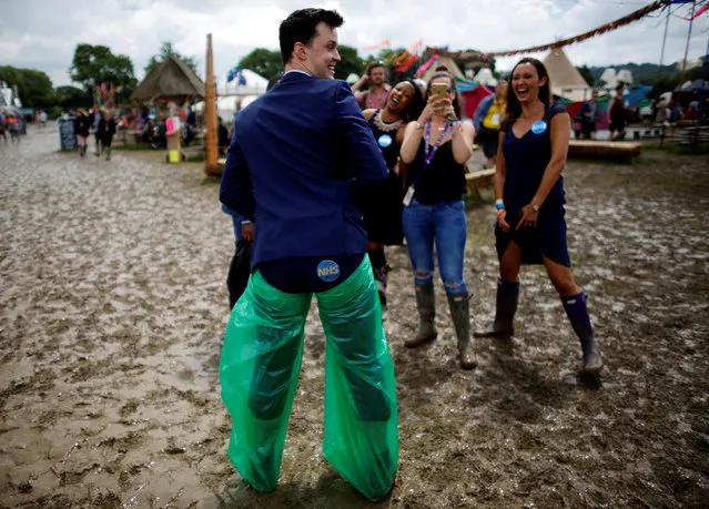 Members of the NHS Choir entertain themselves in the mud at Worthy Farm in Somerset during the Glastonbury Festival, Britain, June 25, 2016. (Photo by Stoyan Nenov/Reuters)