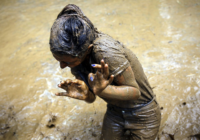 Nepalese students of Himalayan agriculture college play in mud water in a paddy field to celebrate the National Paddy Day in Badegaun village, Lalitpur, Nepal, 29 June 2016. More than 100 students and teachers of Himalayan agriculture college participated in the National paddy day by planting rice and playing in mud water as Nepal is celebrating National Paddy Day with various event. On this day, known as Asar Pandra, farmers begin the annual rice planting season and mark the day with various festivities such as preparing rice meals with muddy water, mud being a symbol for a prosperous season. (Photo by Narendra Shrestha/EPA)